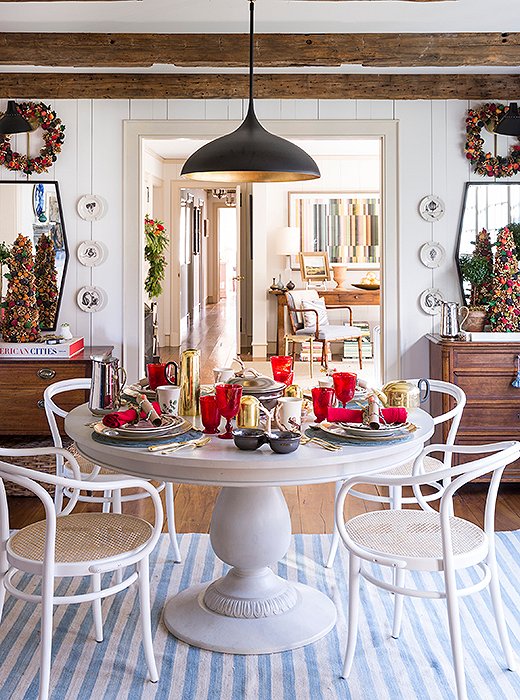 Tones of red and gold warm up the kitchen and balance out the cooler hues found in the home’s front rooms. Find the pendant light here and the dining table here.
 
