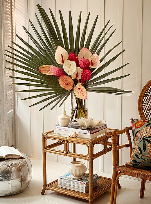For the floral arrangement, two fan palms were used to form a crown around a bundle of pink and white anthuriums. Even without a rattan table to set it on, it’s an accent sure to underscore your tropical point. 
