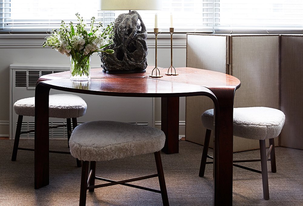 A lava-rock lamp, which is among his favorite pieces in the apartment, complements the dining table’s sculptural shape.
