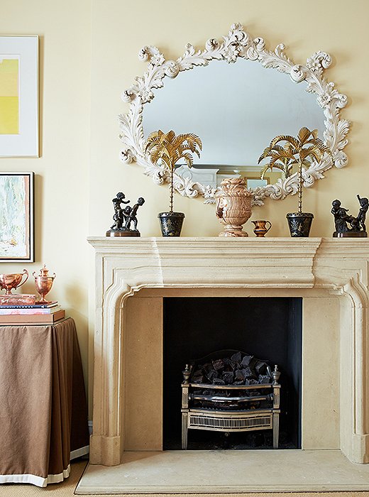 Elegant juxtapositions underlie Amanda’s designs. Case in point: The living room’s limestone mantel is topped with a favorite rococo white plaster mirror and her grandmother’s cast-bronze figurines.
