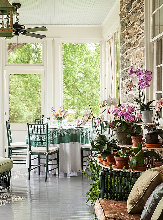 Elizabeth loves to set up meals on the orchid-covered enclosed porch.
