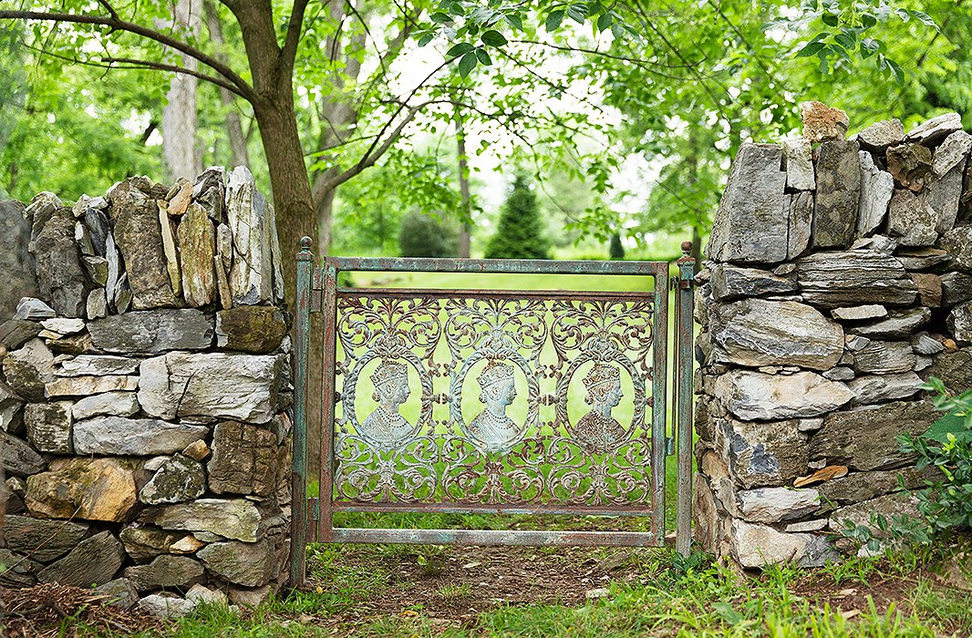 Decades ago when traveling in Udaipur, India, Elizabeth spotted these wrought-iron profiles of the young Queen Victoria. When they created the garden five years ago, she finally installed them. 
