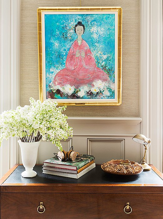 A painting that Nina and her husband discovered abroad hangs above a chest of drawers holding books, magazines, and Nina’s keepsakes. A wooden bowl by Nina’s father makes an elegant catchall for her jewelry.
