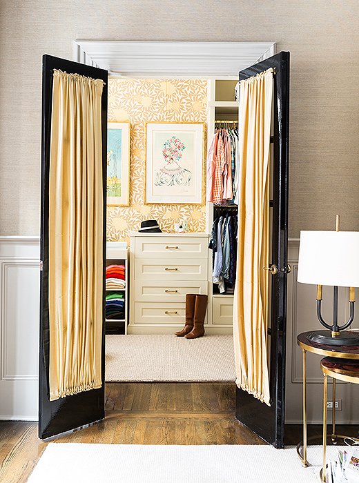 Plaster moldings and doors painted in a Fine Paints of Europe high-gloss black frame the entrance to the spacious walk-in closet, which was once a nursery for Nina’s daughter.
