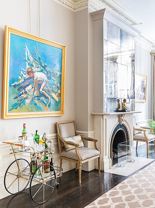 Antiques and heirlooms—including art gifted “from my parents and grandparents, which is always special to be able to pass down,” says Nina—complement the marble fireplace, which is original to the house. The chairs are antique, and the 1940s bar cart sees regular use during predinner drinks.
