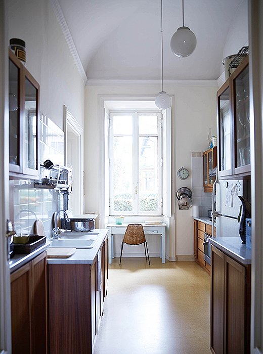 Even in the narrow kitchen, the apartment feels villalike with its soaring arches and long windows.
