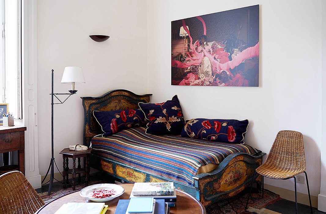 A Venetian bed in the library is perfect for guests in a pinch. Over the bed is a work by Daniela Edburg, which goes beautifully with the embroidered poppies on the pillows.
