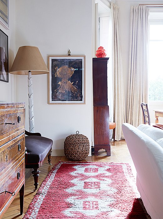 The red in this Turkish rug works with the red on the sofa—as well as the hot red of the ceramic piece atop the highboy.
