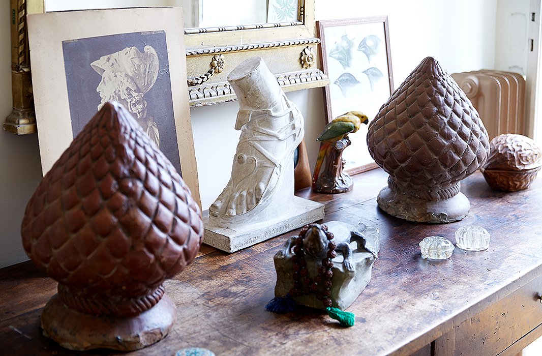 By the hallway to the garden, Peter arranged a tableful of objects—a French plaster cast of the foot of the Apollo Belvedere, Neapolitan pinecones made of terracotta, and a papier-mâché alligator wearing an emerald necklace.
