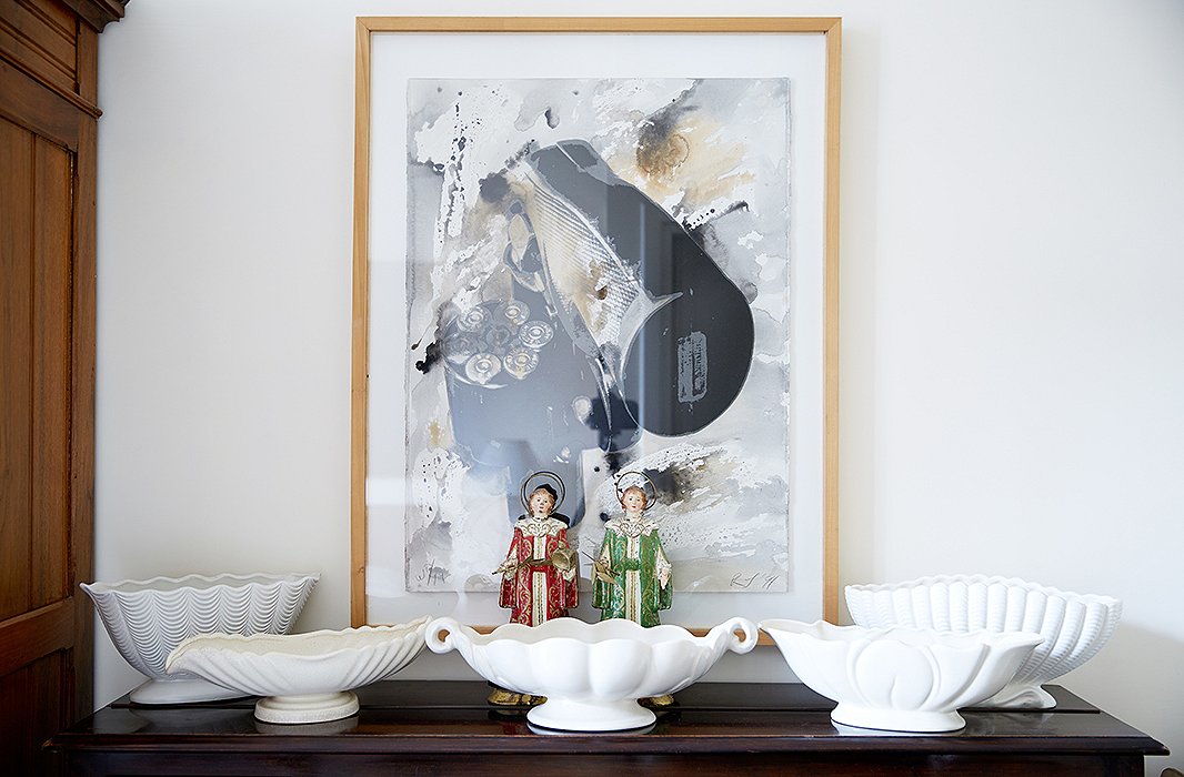 A 1990s lithograph by American artist Robert Longo leans behind another assemblage of white vessels.
