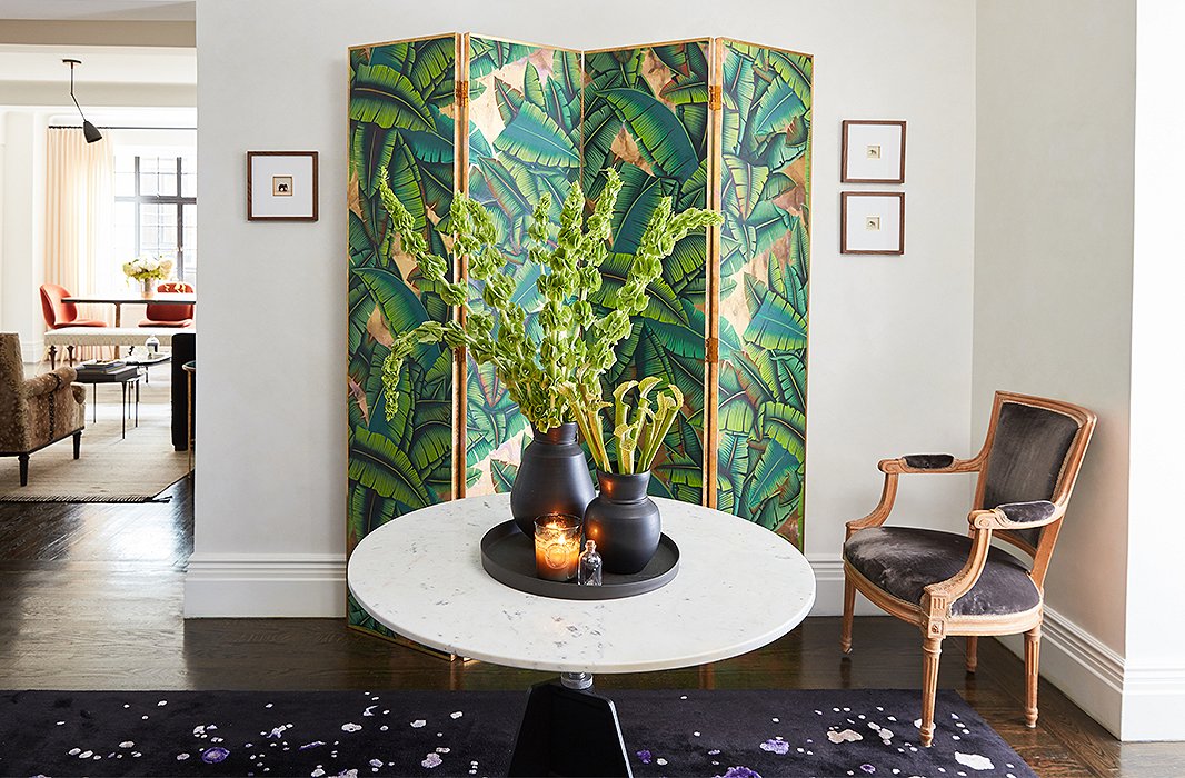 In the foyer, Venetian plaster walls amplify the natural light from neighboring rooms. A palm-leaf print de Gournay screen and a rug by Edward Fields, custom-made for Bennett’s room at the 2015 Kips Bay Showhouse, create an intriguing interplay of color and pattern.

