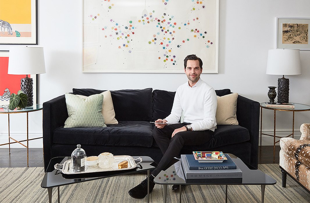 Designer Bennett Leifer in his apartment’s living room, where a pair of cocktail tables and a velvet sofa create a cozy conversation area. The large-scale artwork is a painting by Minjung Kim titled Predestination. The English silver tray adds a note of traditional polish. The Everleigh sofa is similar to that above.
