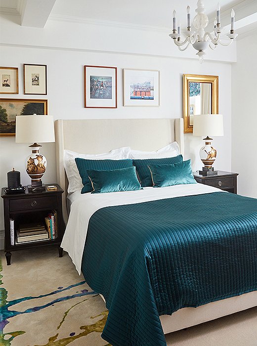 In the master bedroom, the custom carpet’s turquoise streak matches the hue of the bed’s quilt and pillows. Classical lamps by Parzinger and a milky Murano glass chandelier light the space—a pairing as eclectic as the gallery wall surrounding the upholstered headboard.
