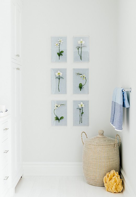 Three-dimensional floral art provides symmetry in the master bath. The jute basket provides texture and warmth to the space.
