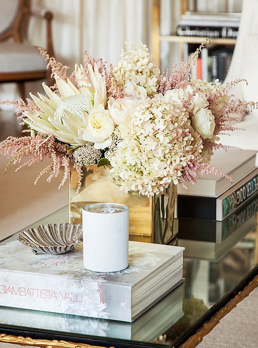 Metallics consistently run through the home’s design. Here, a bold geometric vase plays off the stylized leaflike motif along the gilded coffee table.
