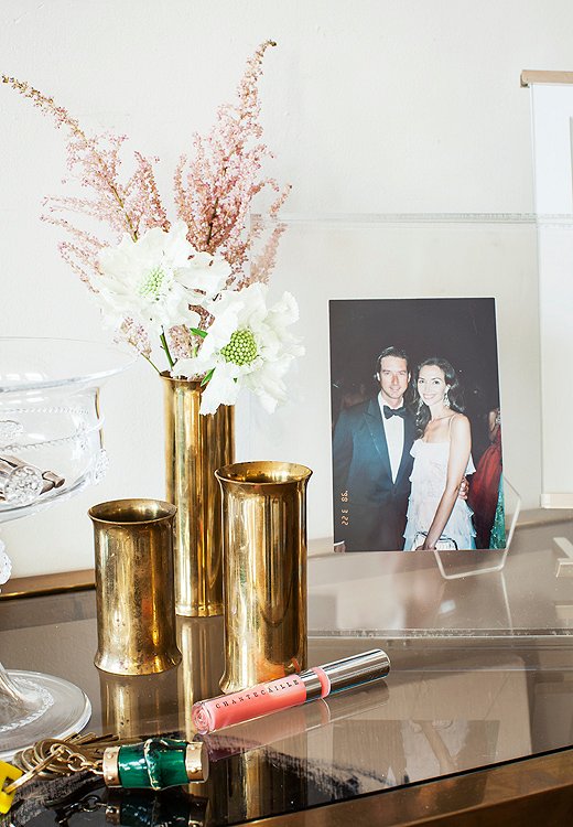 On the entry table, snapshots of the couple and family are mixed among mini brass vases and, of course, handy Chantecaille lip glosses.
