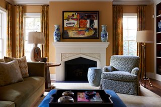 The den is more subdued than the rest of the house but still filled with color. “I wanted to make sure that it was welcoming and livable for long periods of time,” says Dennis. He masters the mix by pairing chinoiseries vases with a modern painting and a Southwest-inspired lamp.

