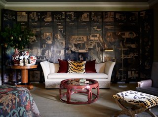 No master suite is complete without a sitting area. Here, Dennis covered the entire wall with a 12-panel chinoiserie screen. He pulls in more traditional elements with Greek key detailing on the sofa.
