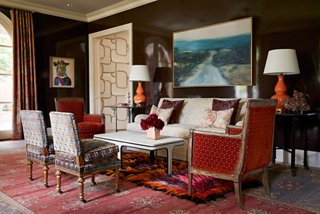 Dennis’s choice to mix eras and styles keeps the room interesting at every turn. Layering a wild shag carpet over an Oriental rug exemplifies his maximalist nature. 
