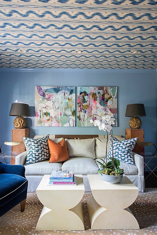 Courtland grew up with a Stark Fauna rug and knew it had to go somewhere in her house; she added it to the pattern-filled den. Orange and blue pillows pull the space together with a conscious play on color.
