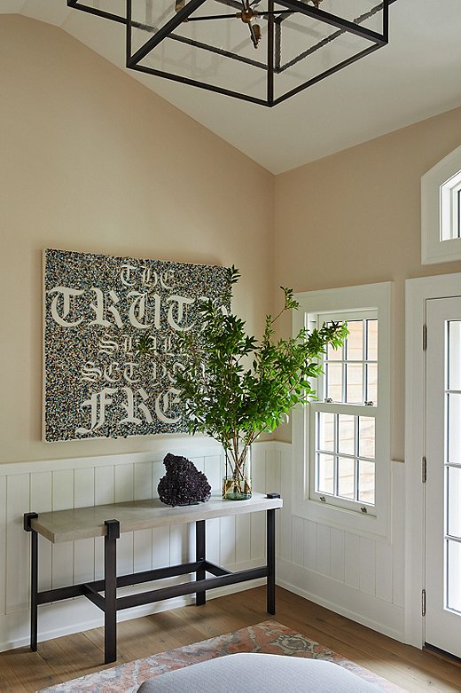 The owners brought the artwork hanging over the console table in the entryway with them. The text reads: “The Truth Shall Set You Free.”
