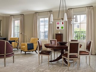 Heather included a more traditional aesthetic for the living room to counterbalance the modern art in the home. She juxtaposed pieces by Andy Warhol and Damien Hirst with Louis XVI chairs and dark wood furniture. (For similar chairs, see the Exeter Side Chair in Saddle Leather.)
