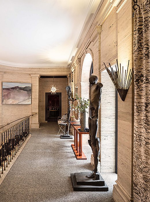 On the second-floor landing, designer Cynthia Spence used eye-catching sconces and life-size sculptures to create a moment of grandeur. Photo courtesy of Cynthia Spence.

