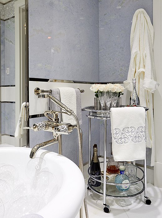 Holiday House founder Iris Dankner's elevated take on a master bath brings the idea of an at-home spa day to new heights. Equipped with a freestanding soaking tub, a fully stocked bar cart, and walls of pale-blue onyx, the room was designed to soothe the senses.    