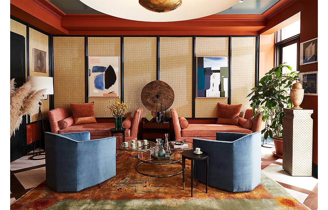 An antique Thai cart wheel from FEA Home makes for an artful focal point between two dusty-pink daybeds. The triple-tiered vintage brass coffee table mimics the lines of the room’s saucerlike pendants, and a Chinese Art Deco-style rug from Rahmanan Rugs adds color and movement. The swivel club chairs are available in six colorways.

