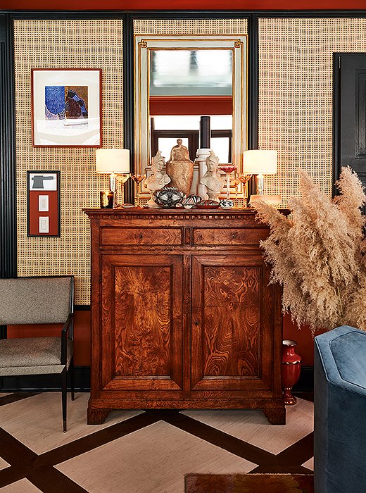 A Federal-style walnut chest speaks to classic American design. On top, antique treasures from Thailand, China, and Japan lend a global layer between two small nickel table lamps. 
