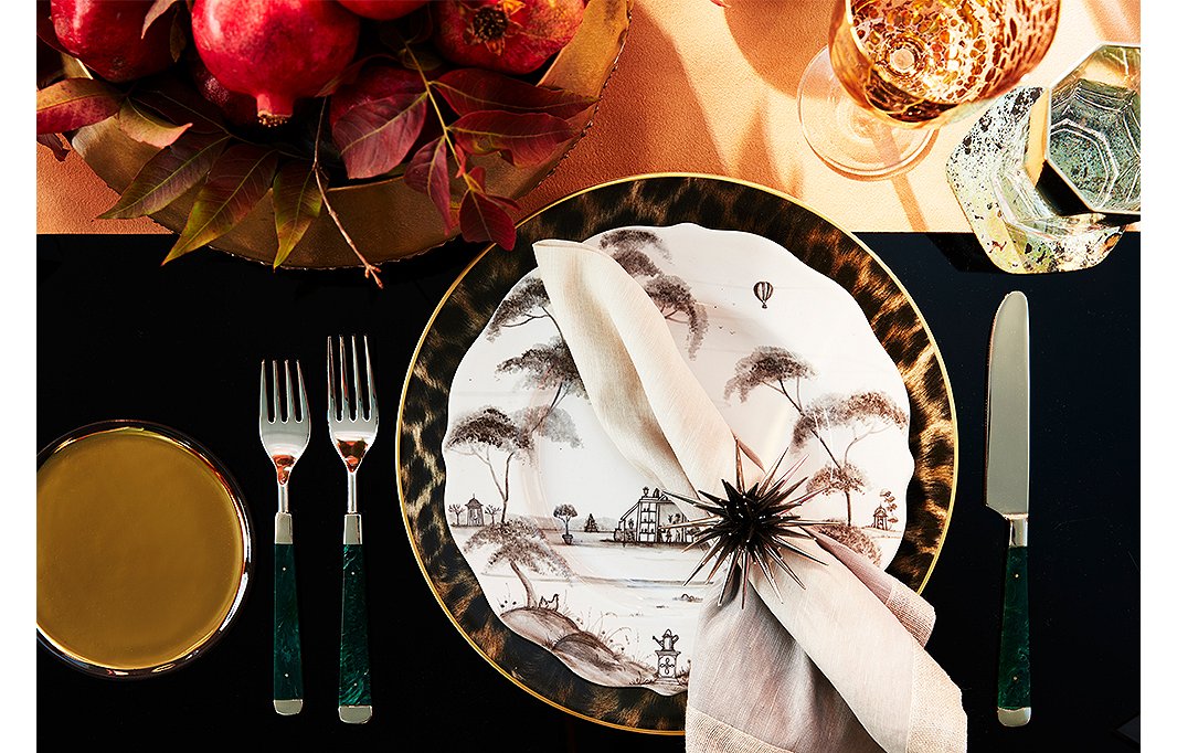 Malachite flatware by Kim Seybert complements plates by Juliska and chargers by Ralph Lauren Home. 
