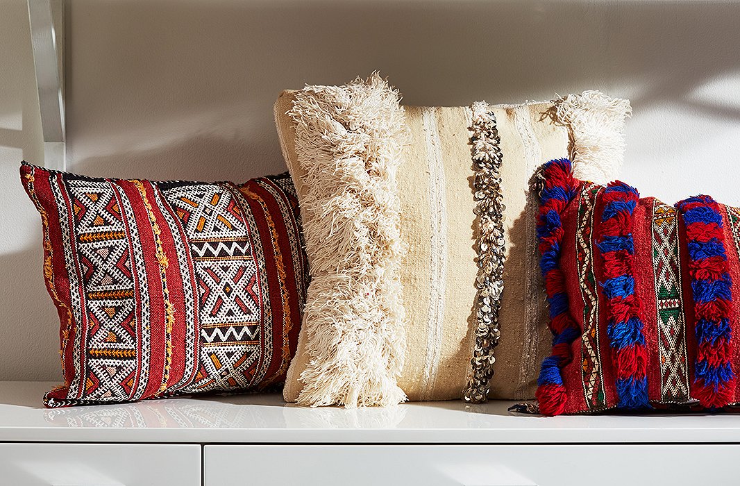 Moroccan Berber textiles encompass a number of styles. On the left, a hand-stitched geometric pillow; in the center, a wedding-blanket style; on the right, a pillow featuring intricate embroidery and fringe.
