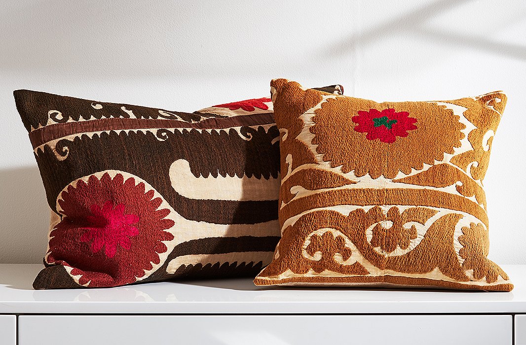 A pair of pillows made from hand-embroidered suzani tapestries.
