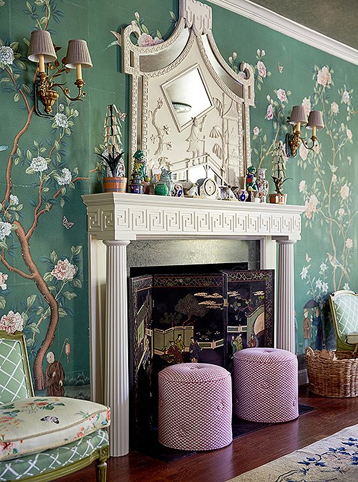 A small folding screen conceals the interior of this fireplace—and provides a pretty backdrop for a pair of upholstered ottomans. A bonus: The ottomans can be pulled out into the living room when extra seating is needed. Photo by Tony Vu
