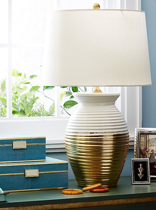 Featuring a body brushed with gold leaf and a hardback silk drum shade, the Ada Jar Lamp is a glamorous, statement-making addition to any room.
