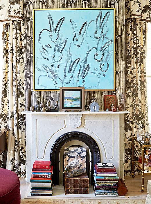 Stacks of books, sculptural objets, and leaning artwork—both on the floor and on the mantel above—give this fireplace an artfully collected look. Photo by Tony Vu
