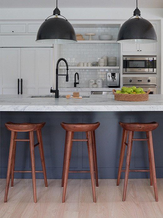 Kelly added wooden stools to the kitchen to bring a level of warmth to the space. Find similar stools here. 
