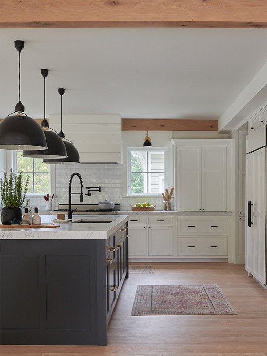 Wood beams and oversize light fixtures steal the show in the kitchen.  
