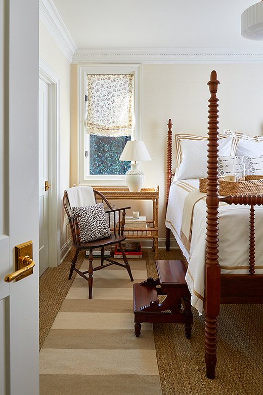 Tone on tone was the key to designing this bedroom. Antique furniture grounds the space, while whimsical details in the window coverings and layered rugs add interest. The walls are painted in Farrow & Ball’s James White.
