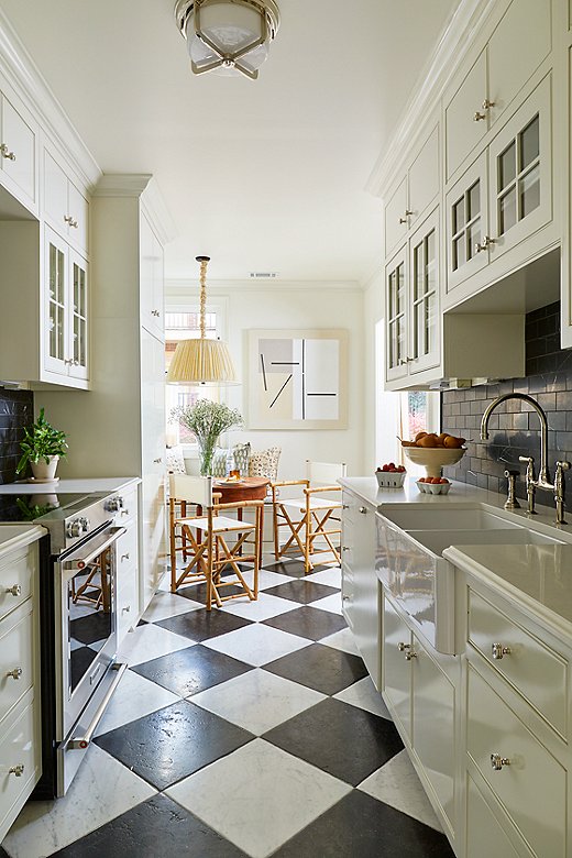 The kitchen received the most attention in Jeremy’s design. He gutted the entire space before introducing new appliances, flooring, and tiles. Abstract art at the end of the galley adds a fun touch to the more traditional black-and-white flooring and color palette.
