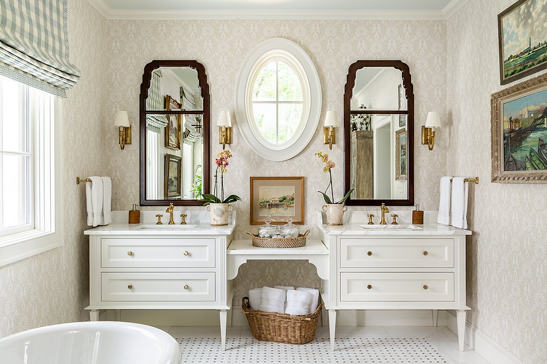 James went light and airy in the main bathroom. Rattan accents, wooden wall mirrors, and art add warmth.
