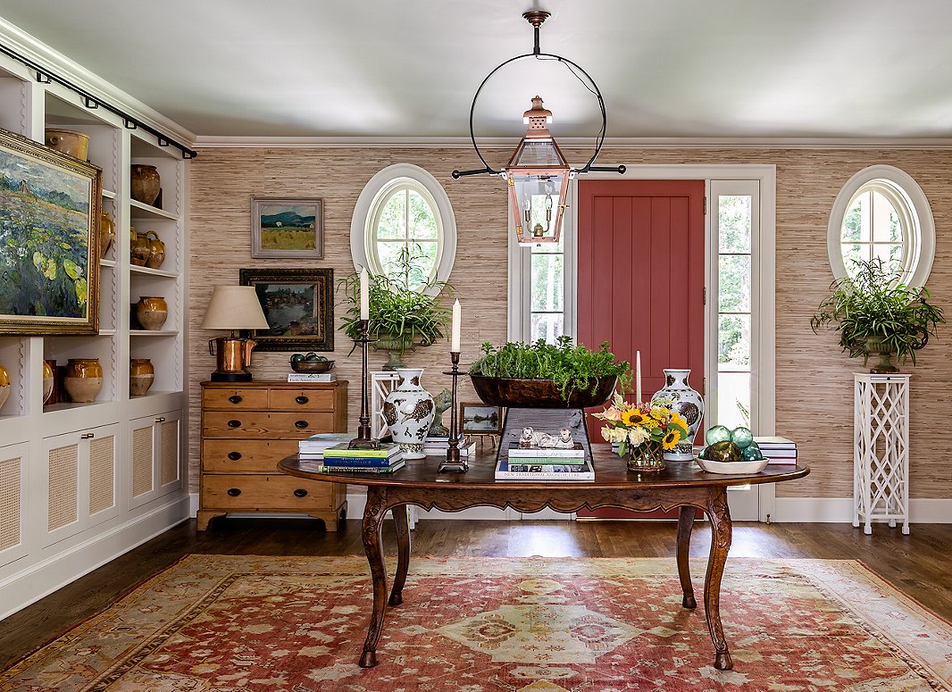 The entry is the best place to make a statement. James went for the layered look, adding in books, pottery, greenery, vases, and other objects. The room, which was opened up during renovation, doubles as a seating area for large parties.
