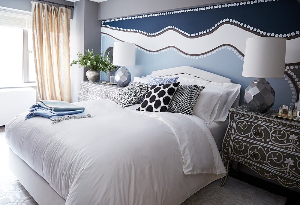 Many of the furniture choices in the bedroom point back to the whimsical hand-painted mural on the wall.
