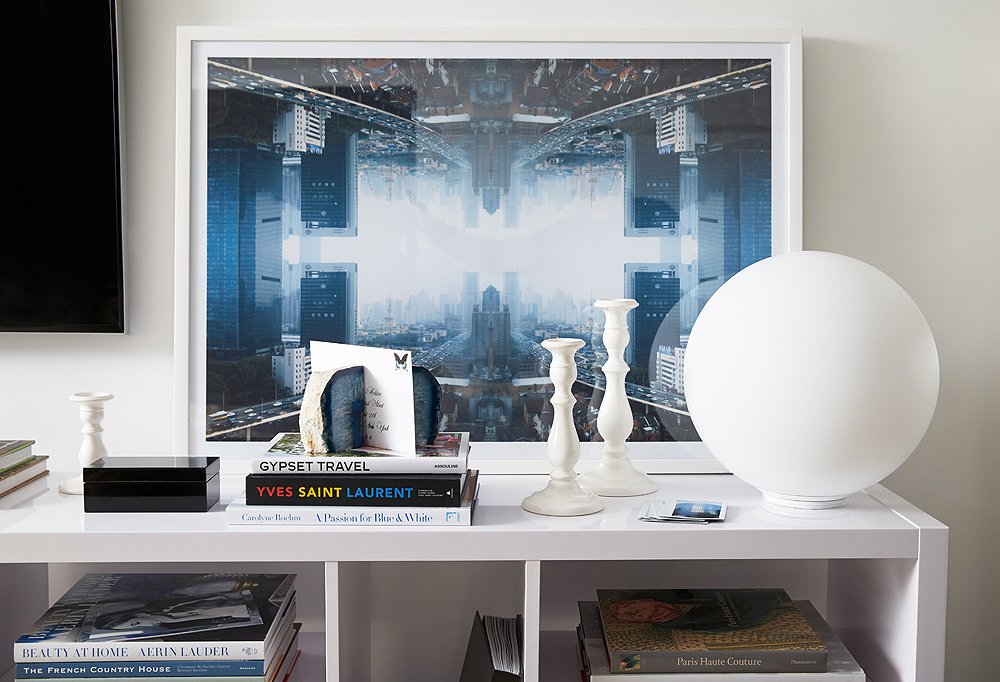 Alongside the flat-screen television, a leaning photograph by Daniel Håkansson stands as a visual counterpoint and striking display amid white accents.
