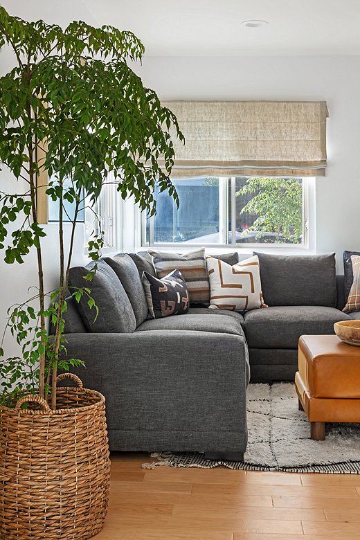 The Morris Crypton Sectional is styled with Kim’s global-inspired pillows (including the Nora Lumbar Pillow, the Wren Pillow, and the Avery Pillow). Also shown is the Cutler Leather Ottoman.
