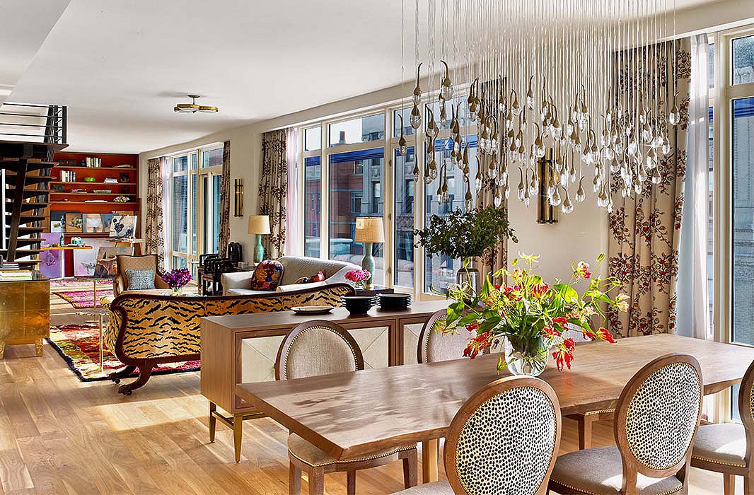 An artful chandelier gives the dining area a sense of presence above a live-edge table and chairs custom-designed by Kati. The sideboard, cleverly floated, helps to delineate the space from the rest of the apartment while providing much-needed storage. 
