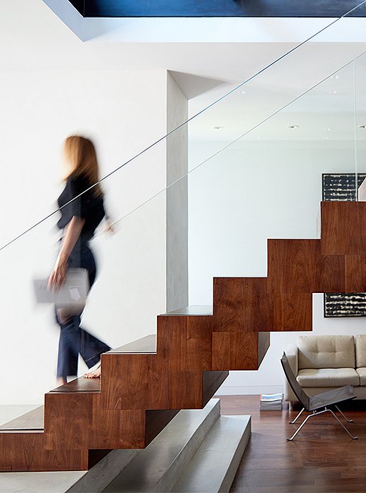 Freestanding stairs constructed of wood, steel, and glass read like a sculpture from all sides. The architects (ZH Architects) were careful to repeat materials throughout the apartment, creating a cohesive visual identity for the home. 
