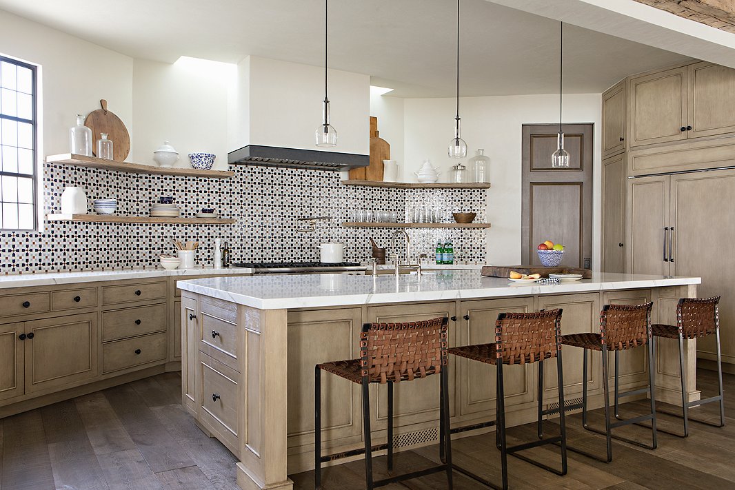 “Again, this is about comfort,” Chris says of the kitchen. “The stools are so sturdy. You really can’t ruin them; they’ll only get better over time.” The cabinets are made of white oak. 
