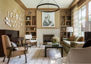 Rift-cut oak is a mainstay in the house. In the formal sitting area in the front of the house, Marie used it to case the ceilings and build out a unique bookcase. The palette in this room brings in a green hue from the dining room just across the entry.
