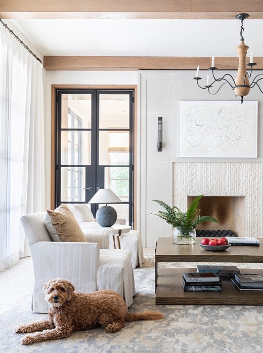 This light and airy living room isn’t as breezy as it first appears, thanks to the dynamic texture of the limestone fireplace. The oak beams on the ceiling play on the home’s rustic Southern sensibility.
